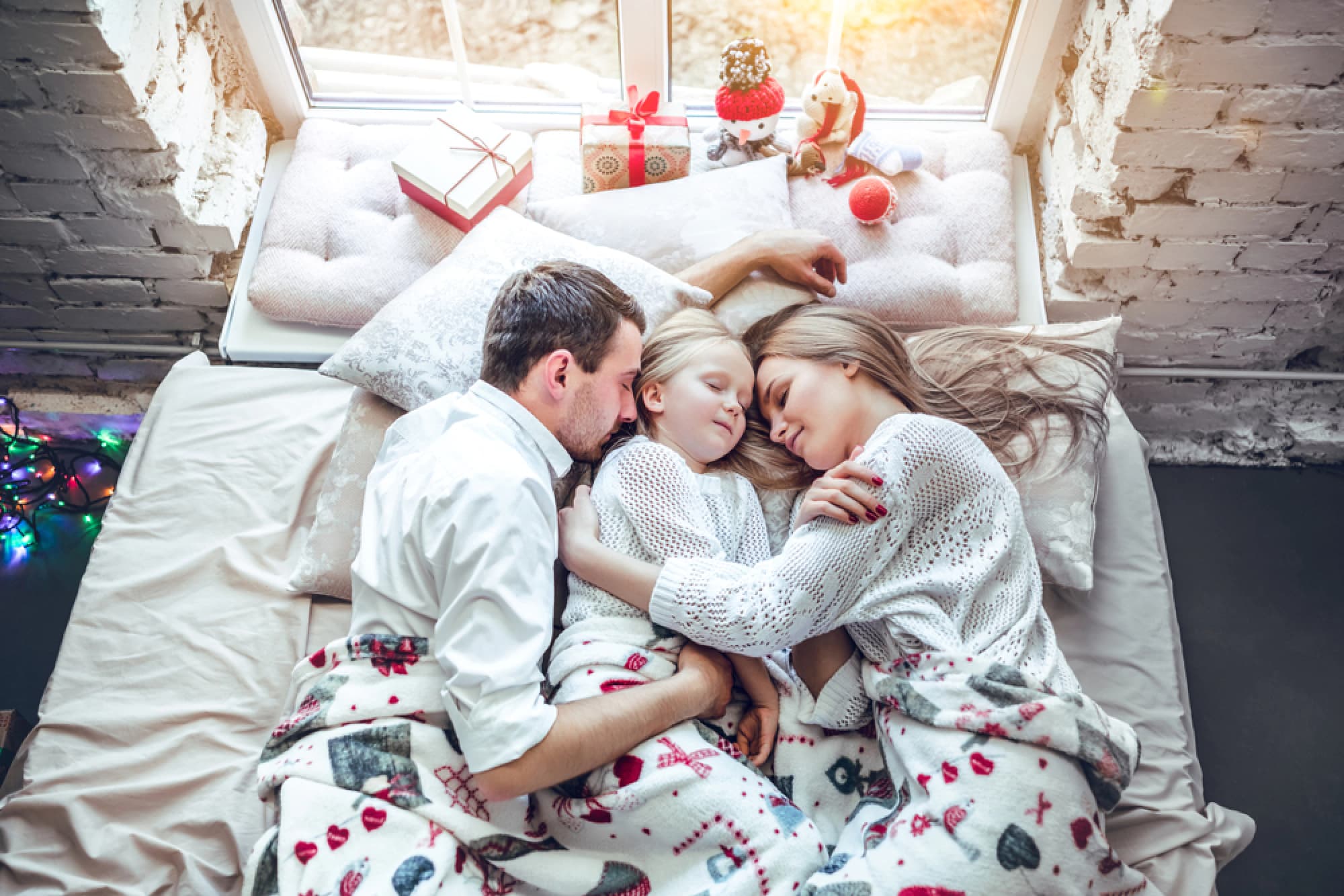 Family in matching Christmas pajamas asleep.