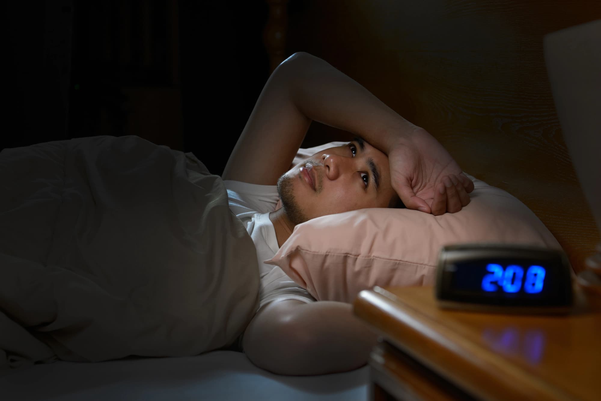 Man lying awake in bed who can’t fall asleep.