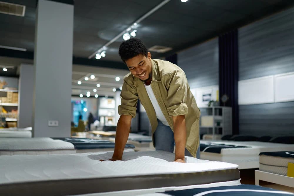 Man shopping in store looking at mattresses