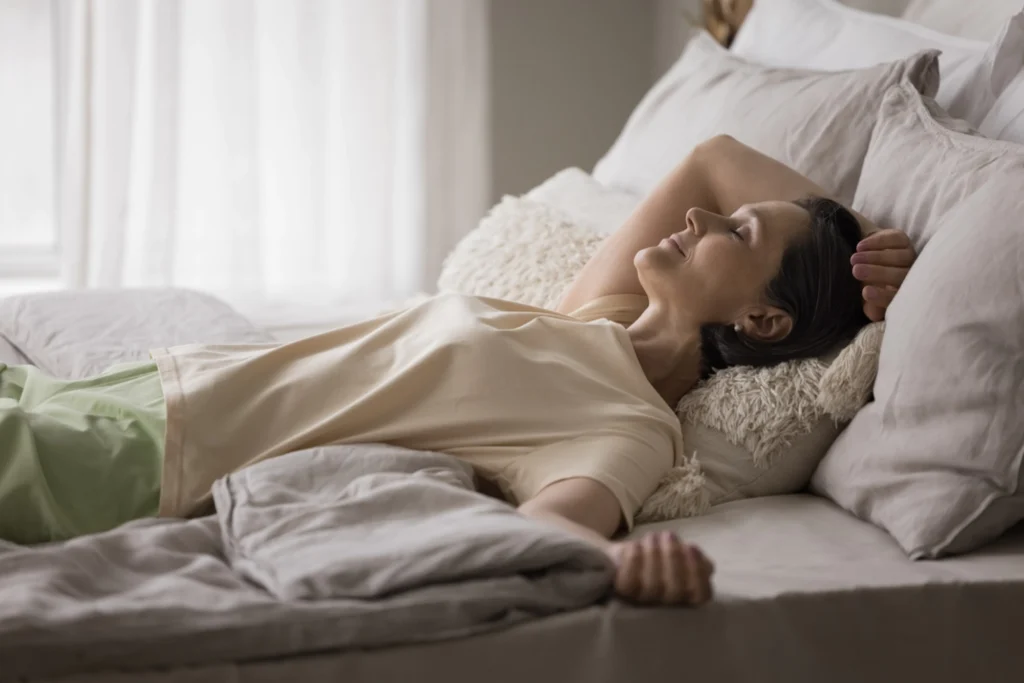 Woman sleeping happily in bed.