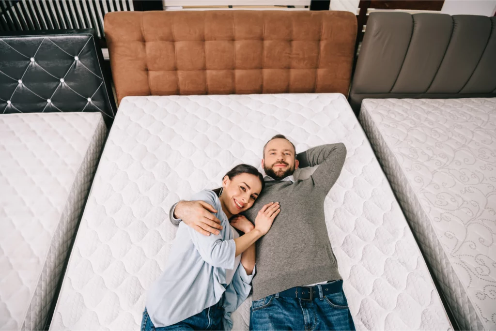 Couple lying on mattress in store.