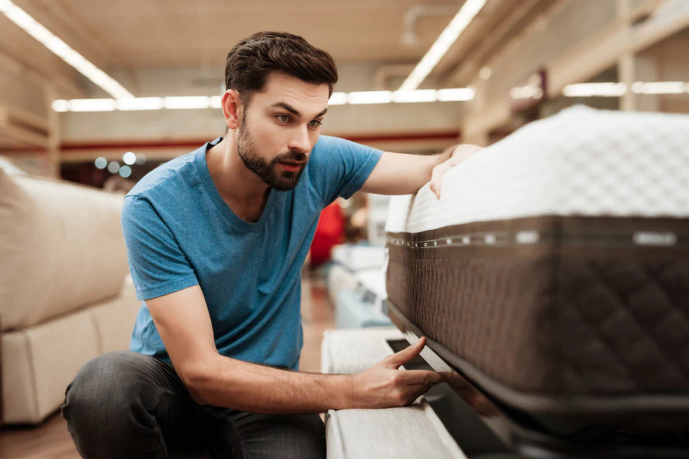 Man shopping for a mattress in a mattress store